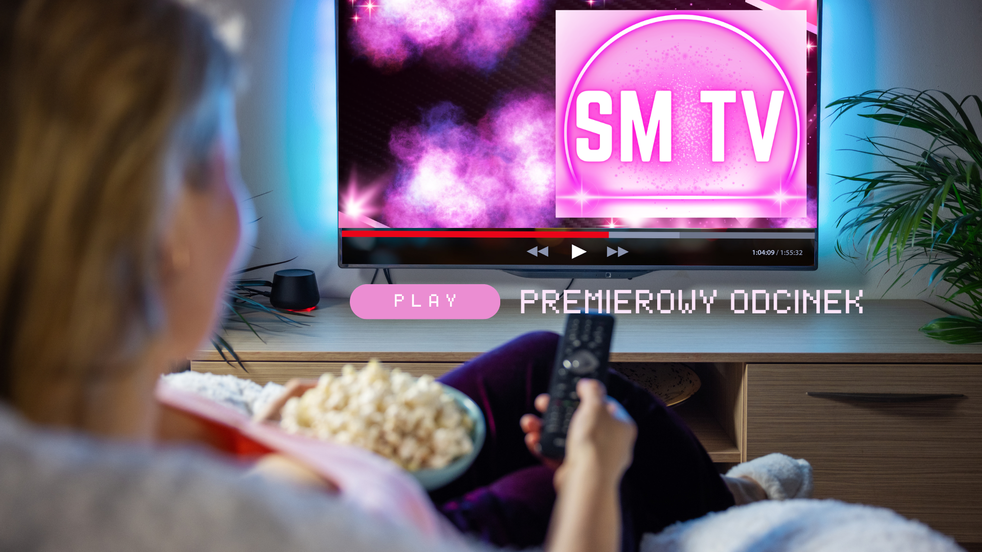 Kobieta siedząca na kanapie, trzymająca popkorn i pilot i włączająca SM TV